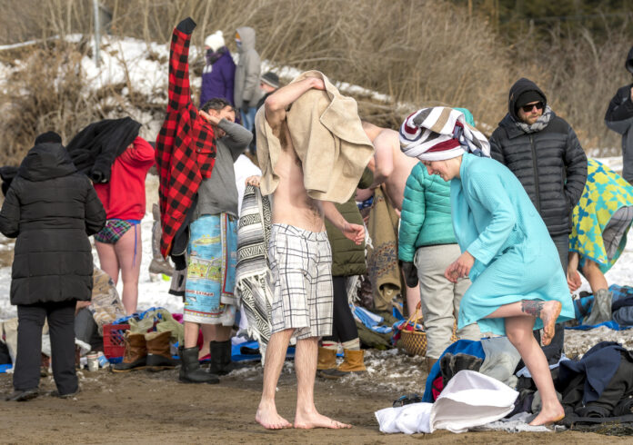 Menschen trocknen sich bei kaltem Wetter ab, nachdem sie Eis baden waren