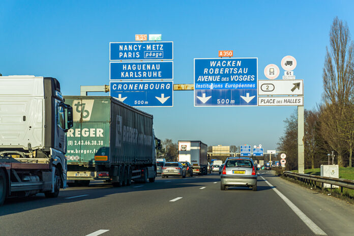 Eine Autobahn mit Autos und Verkehrsschildern im Nachbarland Frankreich.