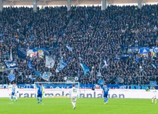 Gleich mehrere Spieler sind auf dem Spielfeld des Karlsruher SC bei einem Fußballspiel angefeuert von den Fans