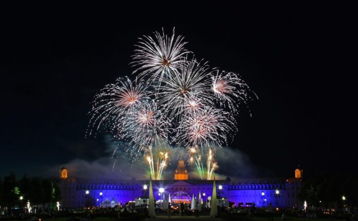 Ein großes Feuerwerk am Nachthimmel von Karlsruhe mit einem ebenso großen Publikum bestehend aus vielen Menschen