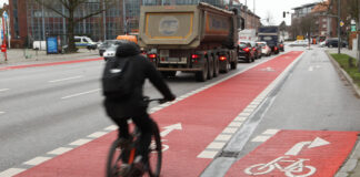 Ein Fahrradfahrer ist auf einem Fahrrad auf einem Radweg durch die Stadt unterwegs