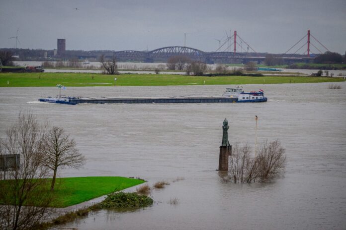 Ein Schiff fährt bei Hochwasser durch den Karlsruher Rhein