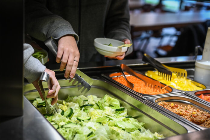 Schüler nehmen sich Salat vom Buffet.