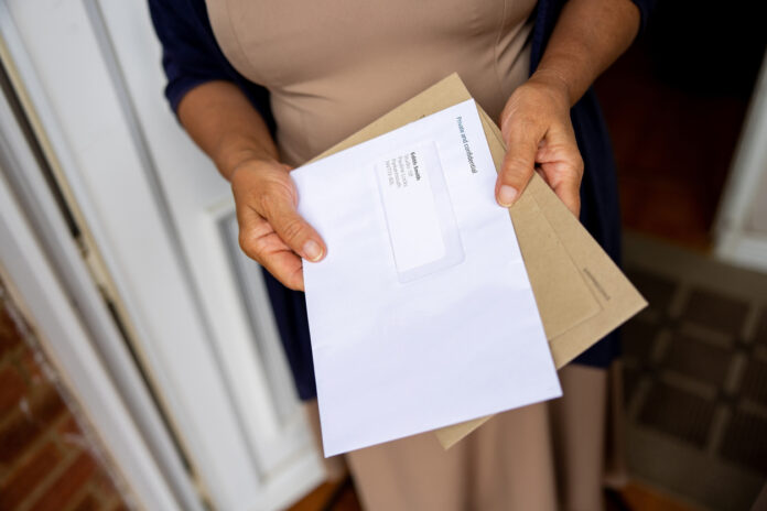 Eine Frau hält die Post in der Hand