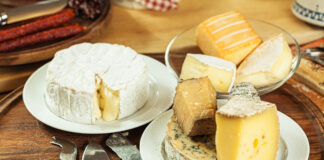 Auf Tellern auf einem Tisch angerichtet befinden sich mehrere Käsesorten wie Blauschimmel, Camembert und Harzer Käse.