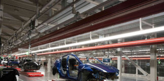 In einer Fertigungshalle werden Autos an einem Fließband gebaut.