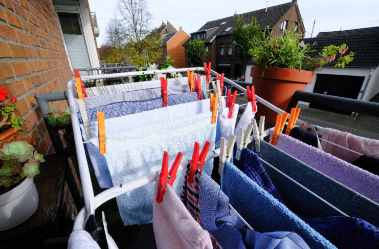 Auf einem Balkon trocknet Wäsche auf einem Wäscheständer.
