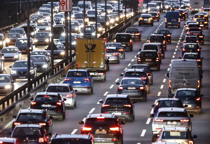 Ein Mega-Verkehrschaos auf einer deutschen dreispurigen Autobahn. Es herrscht stockender Verkehr in der Dämmerung mit mehreren Hundert Pkws in beiden Fahrtrichtungen. Wahrscheinlich kam es zu Sperrungen.