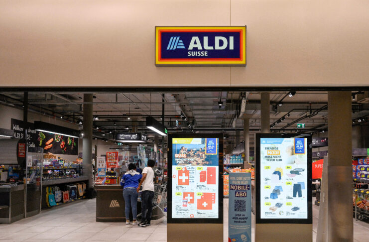 Mehrere Kunden stehen an einer Kasse in einer Filiale von Aldi.