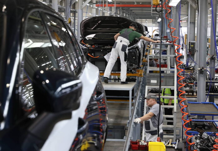 Hersteller arbeiten an E-Autos in der Fabrik. Ein deutscher E-Auto-Standort steht nur kurz nach der Eröffnung vor dem Aus.