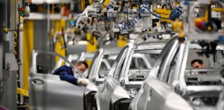 Produktion von Autos in der Fabrik auf dem Laufband. Eine Werk stoppt nun die Produktion von Elektroautos.