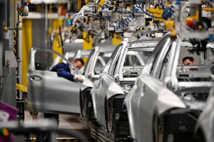 Produktion von Autos in der Fabrik auf dem Laufband. Eine Werk stoppt nun die Produktion von Elektroautos.