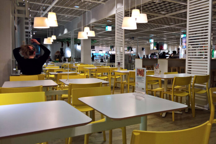 Eine Frau sitzt an einem Tisch in einem IKEA-Restaurant.