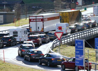 Ein Stau auf einer deutschen Autobahn. Viele Fahrzeuge versuchen über die Auffahrt auf die Autobahn zu kommen. Darunter sind LKW und PKW.