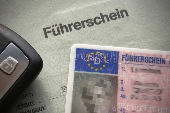 Ein neuer und ein alter Führerschein liegen neben einem Autoschlüssel auf dem Tisch. Der alte Führerschein ist ein weißer Papierführerschein, der durch den neuen EU-Karten-Führerschein ersetzt wird. Diese Führerschein-Änderung betrifft Millionen.