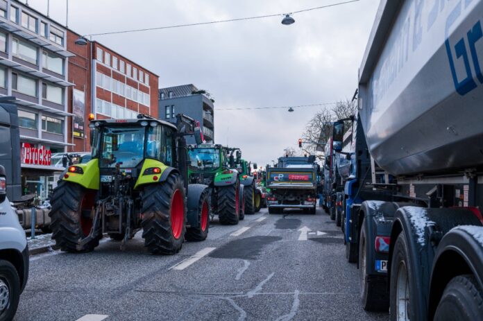 Zahlreiche Traktoren fahren beim Bauern-Protest durch die Straßen und blockieren die Zufahrt