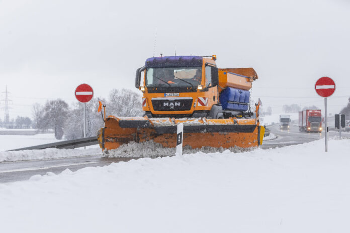 Ein Winterdienst befreit die Straße von Schnee und Eis.
