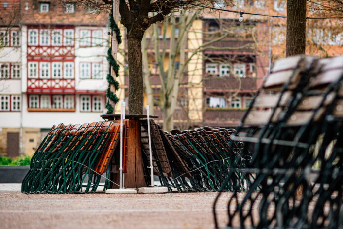 Verschiedene Stühle und Tische sind an einem Baum angekettet. Ein beliebtes Restaurant muss nämlich jetzt schließen.