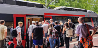 Menschen steigen in einen Zug ein. Das Deutschlandticket soll nun deutlich günstiger werden.