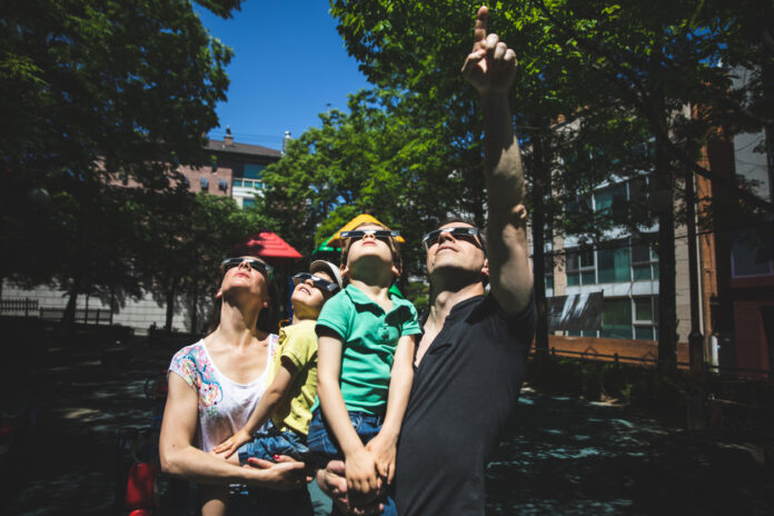 Familie schaut nach oben zur Sonnenfinsternis
