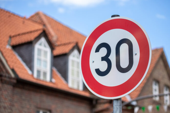 Tempo-30-Zone und ein Schild für das Geschwindigkeitslimit von vorn