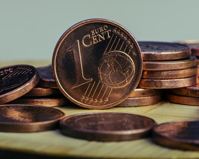 Auf einem Tisch liegen viele 1 Cent Münzen.