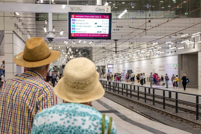 Zwei Fahrgäste blicken voller Erwartung auf die S-Bahn-Linie