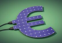 Ein blaues Eurozeichen aus Solarzellen liegt auf einem grünen Hintergrund.