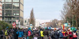 Hunderte Klima-Teilnehmer an einer Klimademonstration stehen auf einer Straße mit Fahrrädern