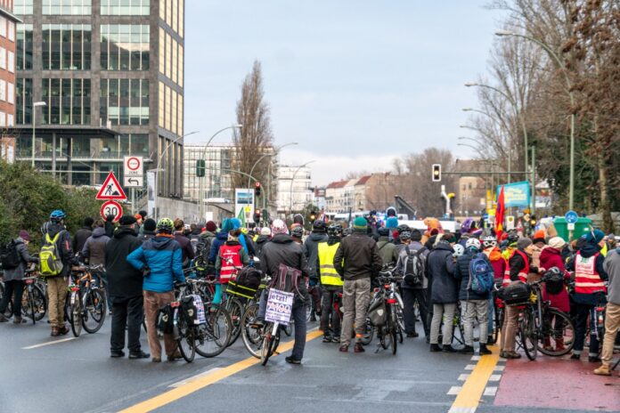 Hunderte Klima-Teilnehmer an einer Klimademonstration stehen auf einer Straße mit Fahrrädern