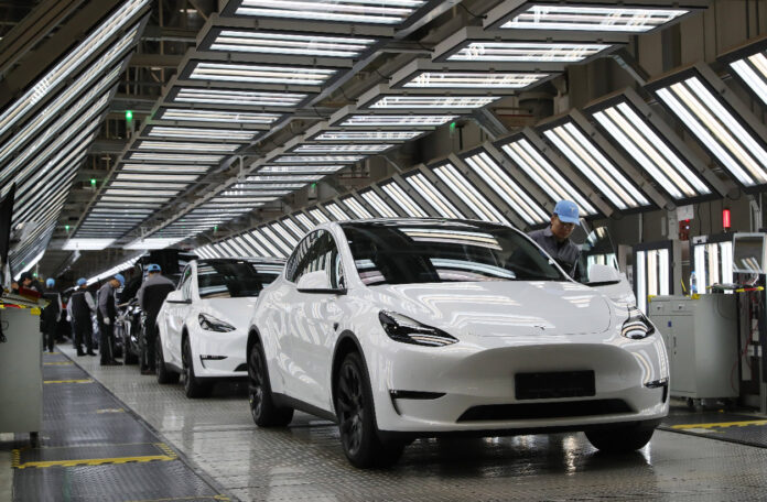 Tesla E-Autos am Fließband in Werkstatt.