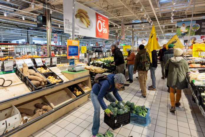 Kunden in Supermarkt greifen bei Schnäppchen in der Obstabteilung zu.