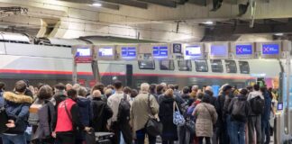 Viele Fahrgäste warten auf das Ankommen der deutschen Bahn oder des ICE am Bahnsteig in einem Bahnhof
