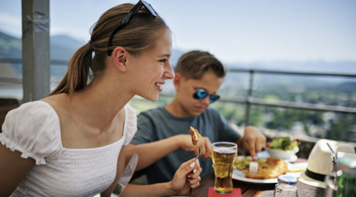 Ein Mädchen und ein Junge essen in einem Restaurant auf einer Terrasse bei schönem Wetter