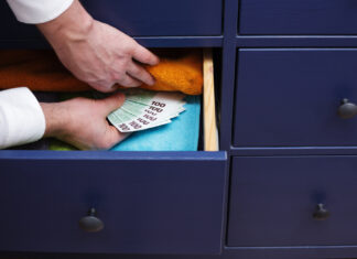 Ein Mann versteckt einen großen Betrag in einer Schublade.