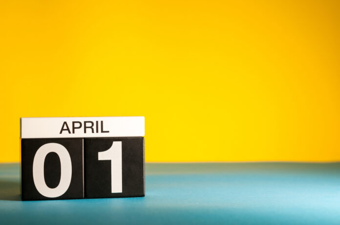 Vor einem gelben Hintergrund zeigt ein Schild den 01. April an.