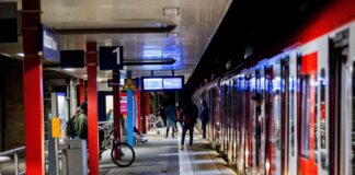 Fahrgäste steht an der Haltestation einer S-Bahn mitten in der Nacht