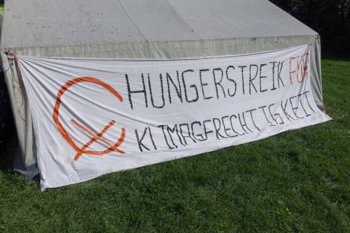 Klimaaktivisten treten in den Hungerstreik und haben ein Banner aufgehangen