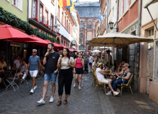 Mehrere Touristen bummeln durch die Altstadt von Heidelberg. Ein Traditionscafé schließt jetzt für immer seine Türen.