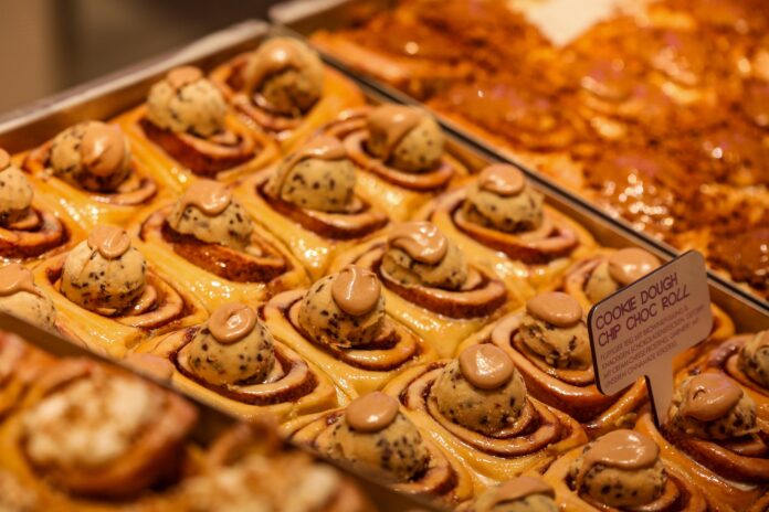 Zimtschnecken mit unterschiedlichen Zucker Dekors in einer Auslage einer Bäckerei oder eines Cafes