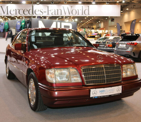 Ein roter Mercedes Benz aus den 90er Jahren auf einer Automobilmesse.