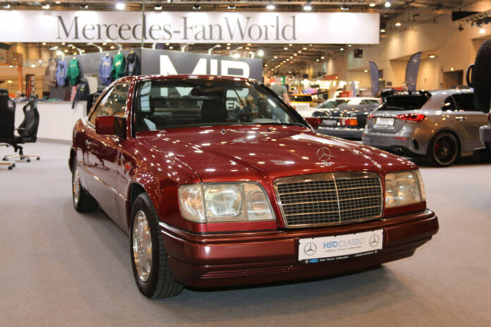 Ein roter Mercedes Benz aus den 90er Jahren auf einer Automobilmesse.