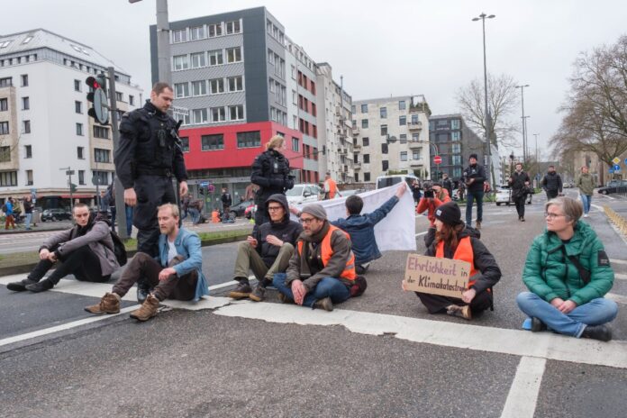 Die Klimaaktivisten der letzten Generation sitzen auf einer Straße, um sie zu blockieren