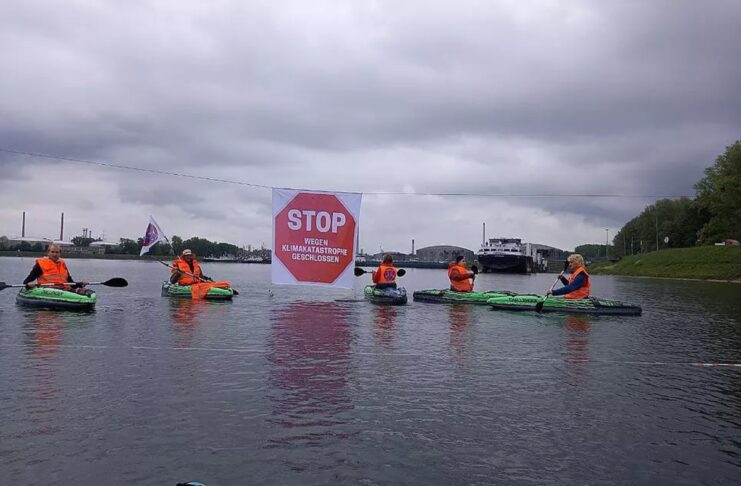 Klima-Aktivisten mit Booten auf Wasser.