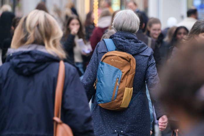 Eine Frau mit Rucksack in einer Einkaufsstraße