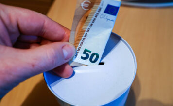50 Euro werden in eine Spardose gesteckt.