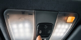 Eine Person schaltet die Innenbeleuchtung im Auto ein.