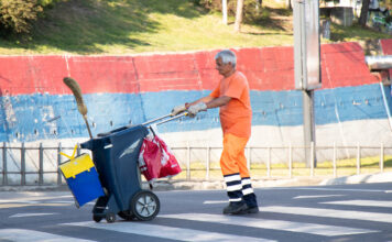 Ein älterer Mann arbeitet als Müllmann.