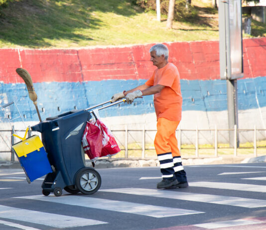 Ein älterer Mann arbeitet als Müllmann.