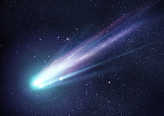 Ein heller und großer Komet am Himmel neben Sternen.